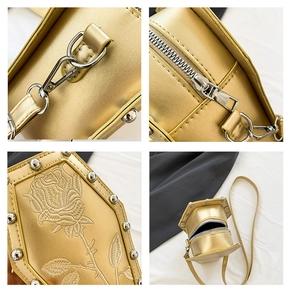 Detail of rose embroidery and silver stud rivets on the gold coffin-shaped shoulder bag