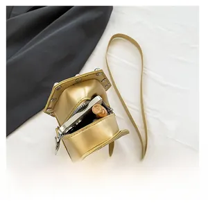 Detail view of gold rivet crossbody bag showing internal space for phone and lipstick
