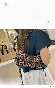 Detailed close-up of leopard print baguette bag with slim shoulder strap design