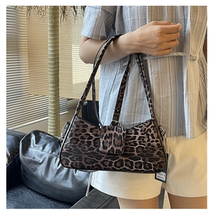 Detailed view of leopard print baguette bag with textured fabric and slim shoulder strap
