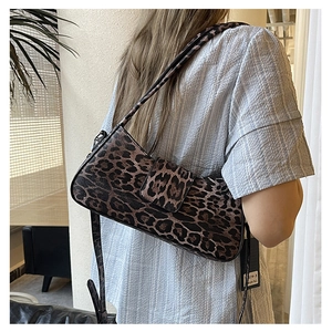 Detailed view of leopard print baguette bag with silver hardware on a striped shirt