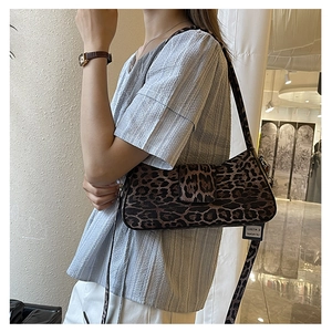 Detailed side view of trendy leopard print underarm bag on model with silver buckle