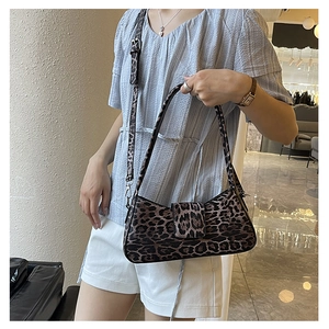 Close-up of leopard print baguette bag featuring flip cover and dual strap system