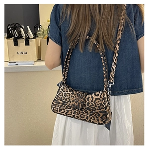 Detail of vintage leopard print shoulder bag with wide strap on a fashion model