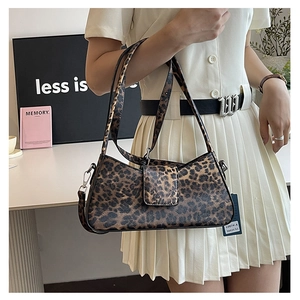 Model wearing a vintage leopard print baguette bag with a sleek flap closure and thin straps