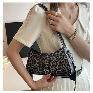 Detailed view of leopard print texture on leather baguette bag with metal hardware