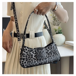 Detail of leopard print handbag with detachable shoulder strap and metallic hardware