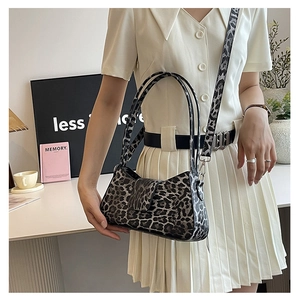 Detail shot of leopard print baguette bag with adjustable shoulder strap and flap closure