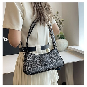 Close-up of leopard print baguette bag worn with a chic pleated dress for a modern look