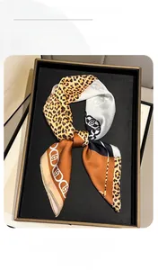 Detail of silk-feel scarf featuring leopard print and vintage chain patterns in brown