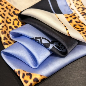 Detailed view of leopard print and blue geometric satin scarf with silky texture and shine