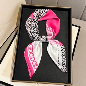 Elegant satin scarf with pink color-block and leopard print displayed on a black tray