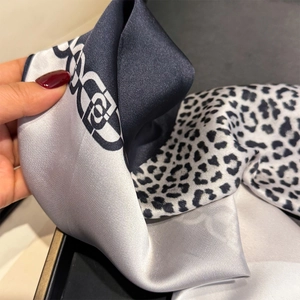 Close-up of leopard print and geometric chain patterns on a soft faux silk scarf
