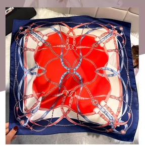 Close-up of geometric chain pattern silk scarf with red, white, and navy blue contrast