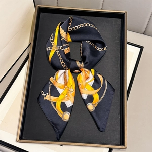 Detailed close-up of luxurious silk scarf with golden chain patterns on navy background