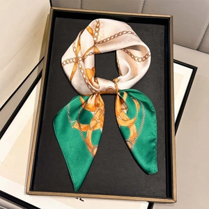 Elegant white and green silk square scarf with gold chain patterns on display
