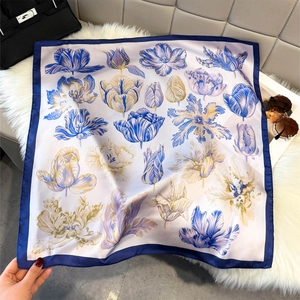 Detail of floral silk square scarf with blue tulip print on a premium plush background