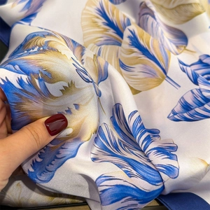 Detail of silk scarf showing smooth texture and blue floral print with elegant drape