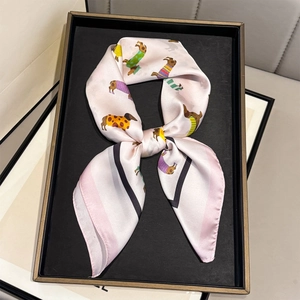 Rosa Seidenschal mit bunten Dackeln und Kontrastrand auf einem Display-Tablett präsentiert