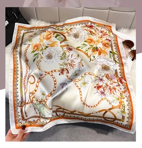 Close-up of floral print silk scarf with chain pattern on soft faux fur surface
