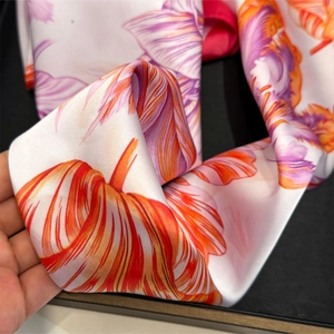 Detailed view of lightweight tropical leaf floral silk scarf with vibrant orange and purple prints