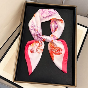 Detailed view of floral silk scarf featuring pink tulip prints and a magenta border