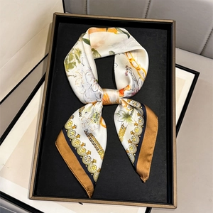 Detail of floral silk scarf with gold chain patterns in an elegant display tray