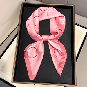 Elegante roze zijden sjaal met rode cirkelpatronen, gestyled als een chique decoratieve das
