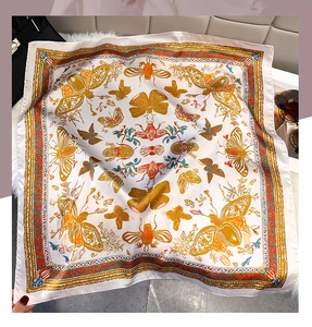 Detail of faux silk butterfly print scarf on soft plush fabric with leather bag