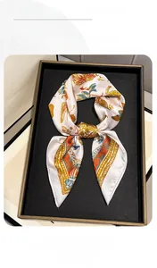 Close-up of butterfly print silk scarf with floral patterns on a display tray