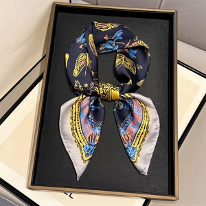 Close-up of silk scarf featuring yellow butterfly prints and grey stitched edges