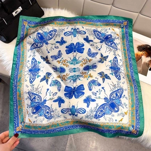Detailed pattern of silk butterfly scarf with luxury bag on a soft plush background