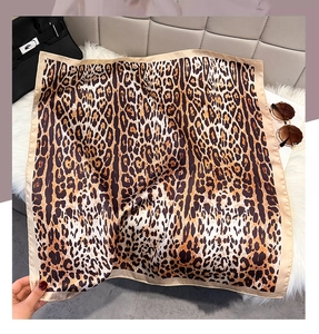 Detail of leopard print silk scarf with fine stitching and smooth satin texture