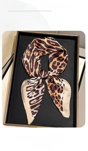 Macro detail of silky earth-tone leopard print scarf with high-gloss smooth texture