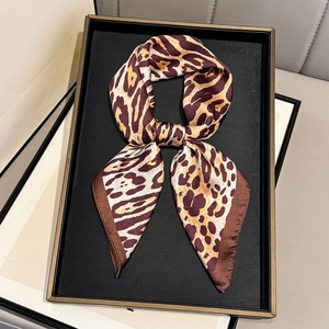 Close-up of leopard print silk scarf showing smooth texture and detailed hem work