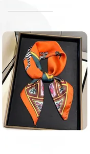 Détail d'un foulard en soie à imprimé zèbre orange sur un plateau de présentation