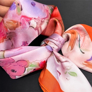 Macro detail of oil painting floral silk scarf showing fine texture and hem stitching