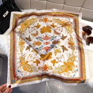 Silky square scarf with butterfly print on white fur background with luxury accessories
