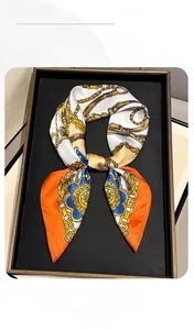Detailed view of the luxury chain and belt print on the orange and blue satin scarf