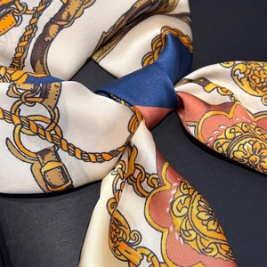 Close-up of silk-feel scarf with chain print showing elegant satin texture and neat edges