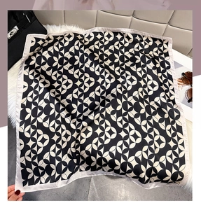 Detail of square silk scarf with black and white geometric patterns and fine grey edges