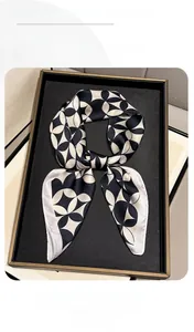 Close-up of geometric star pattern on a silky black and white square scarf