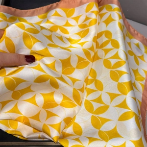 Detail of yellow and white geometric silk scarf with satin luster and pink edges