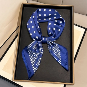Royal blue polka dot silk-like square scarf for women presented on a display tray