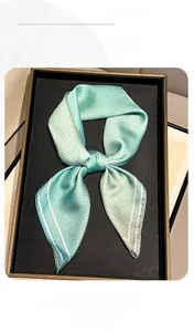 Detailed macro view of mint green satin square scarf with white floral dot patterns