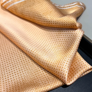 Detailed view of the fine polka dot texture and satin sheen on this elegant silk scarf