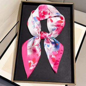 Detail of silk scarf with pink and blue floral patterns on black display tray