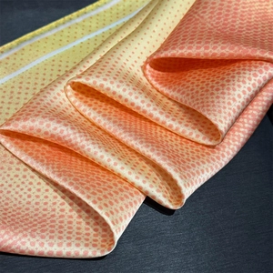 Detail of satin gradient silk scarf with soft red polka dots and smooth texture