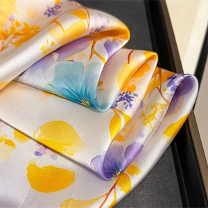 Detailed macro view of the silky floral print scarf with elegant satin luster and texture