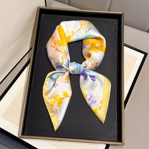 Floral print silk scarf with yellow, purple, and blue patterns in a gift tray